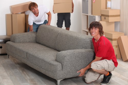 Professional movers carrying furniture during a Fulham flat relocation